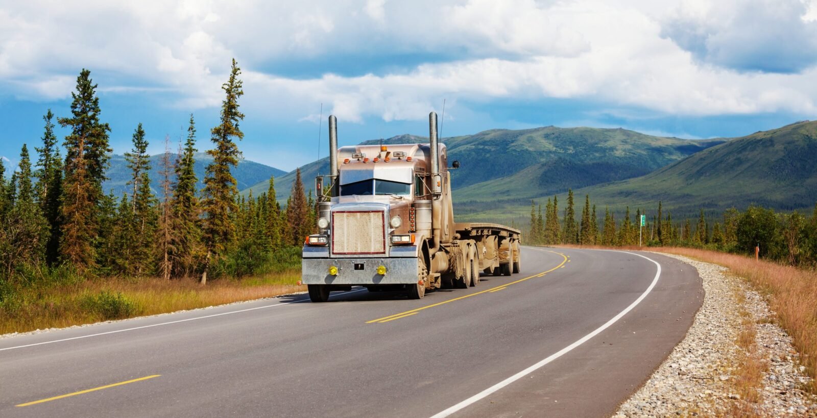 A truck running a highway through open country